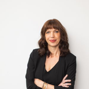 photo of Sara Archambault, a light-skinned woman with brown hair, wearing a black blazer and shirt.